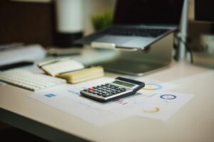 desk with calculator and laptop