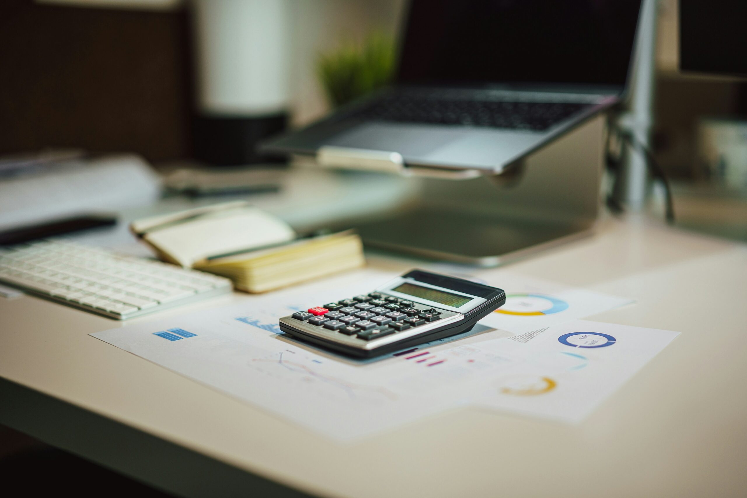 desk with calculator and laptop
