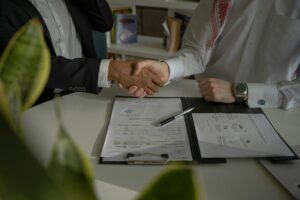 two people shaking hands over agreement