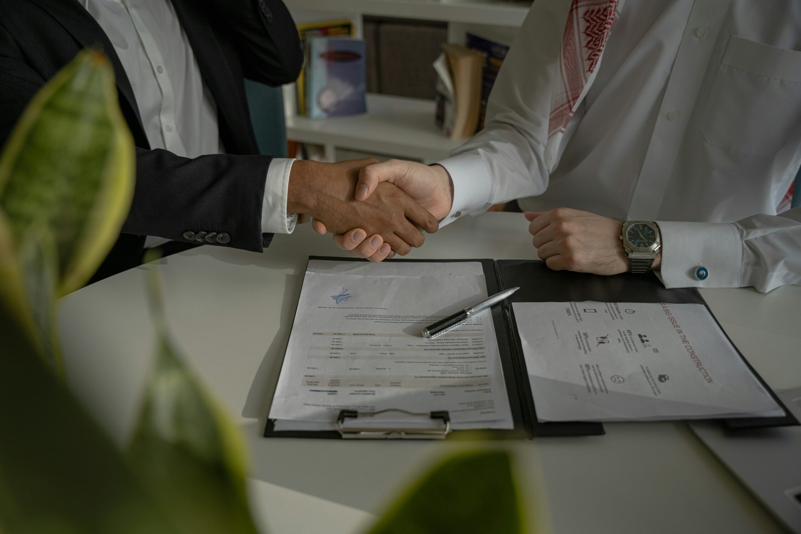 two people shaking hands over agreement